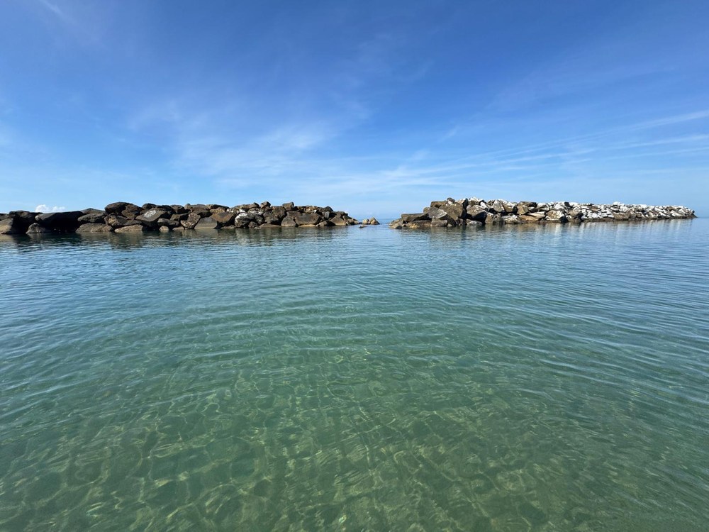 L'acqua limpida davanti al Bagno Azzurro, riparata dalla scogliera di Marina di Pisa