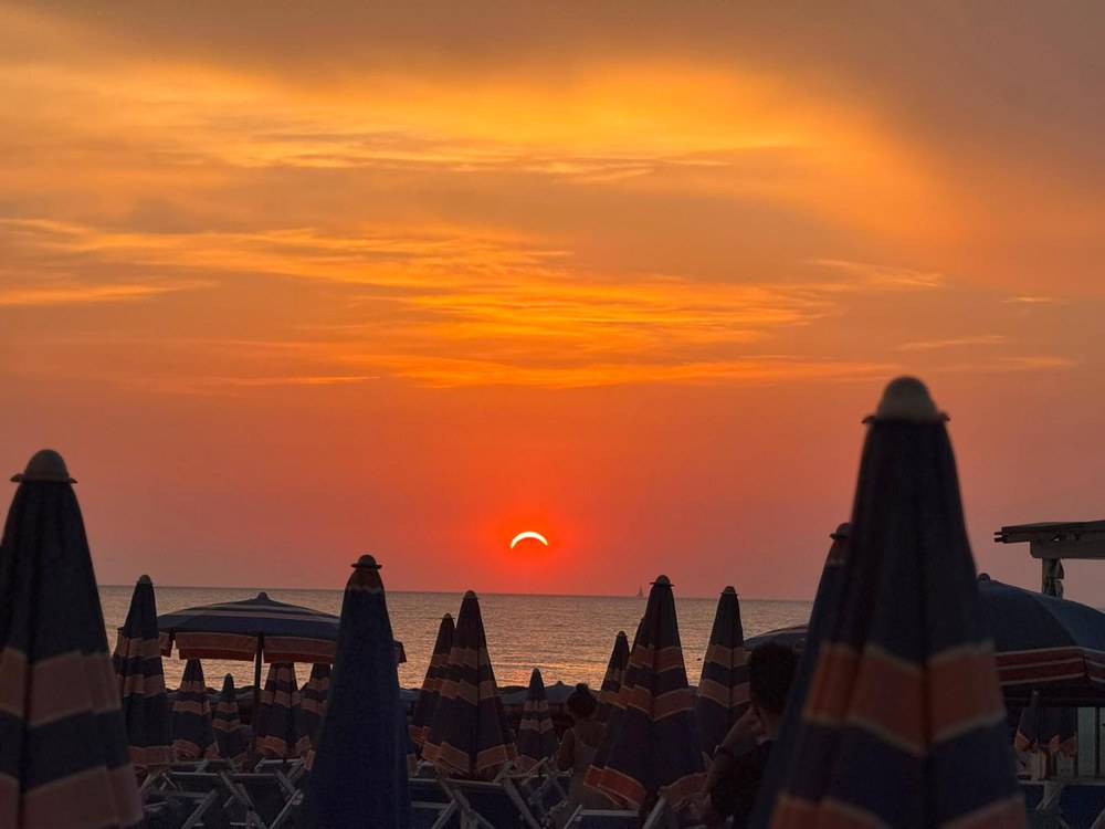 Il tramonto sul mare visto dal Bagno Azzurro, fra gli ombrelloni chiusi